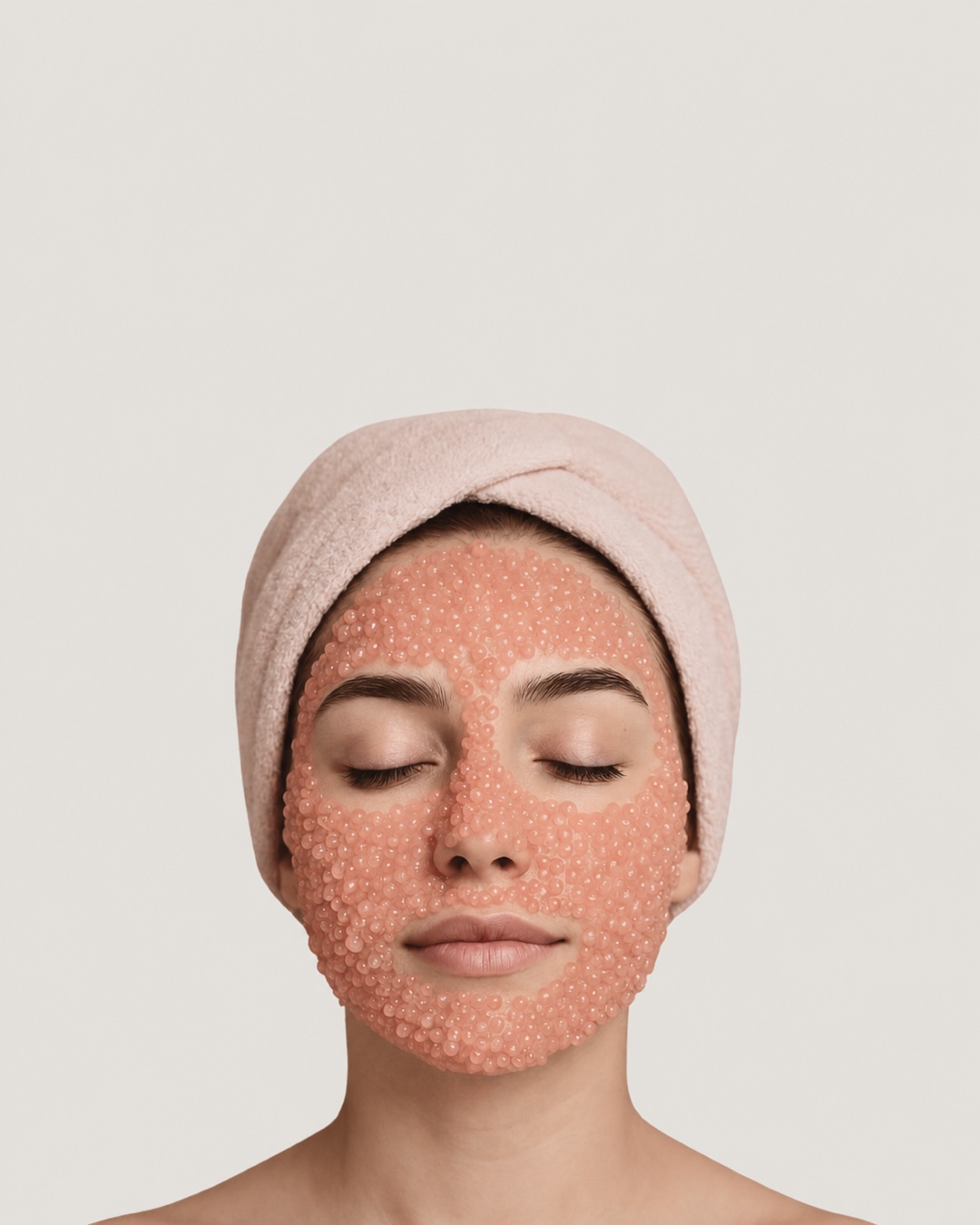 Client wearing a salmon-pink PDRN jelly mask with a blush spa headband